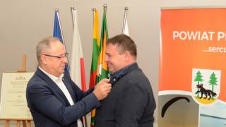 Andrzej Nowicki Starosta Piski dekoruje Norberta Nowickiego Prezesa Fundacji FRRED